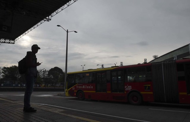 Venezuelan national Jhonger Pina, 25, awaits at a bus station in Bogota, before getting a bus to sell candies and show Bolivar bills as a curiosity to passengers in exchange for local coins, on October 26, 2017. Up to October 2017 there were 470,000 Venezuelans in Colombia, who left their country to escape the hardship and violence of its economic and political crisis. / AFP PHOTO / Raul Arboleda / TO GO WITH AFP STORY by Daniela QUINTERO and Santiago TORRADO