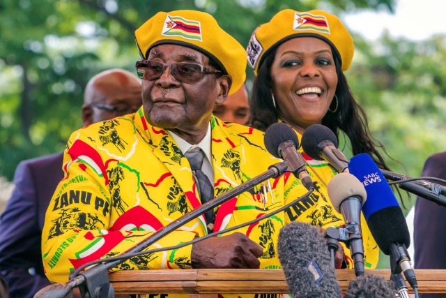 (FILES) This file photo taken on November 8, 2017 shows Zimbabwe's President Robert Mugabe (L) addressing party members and supporters gathered at his party headquarters to show support to Grace Mugabe (R) becoming the party's next Vice President after the dismissal of Emerson Mnangagwa. Several tanks were seen moving near the Zimbabwean capital Harare on November 14, 2017 witnesses told AFP, a day after the army warned it could intervene over a purge of ruling party officials. / AFP PHOTO / Jekesai NJIKIZANA