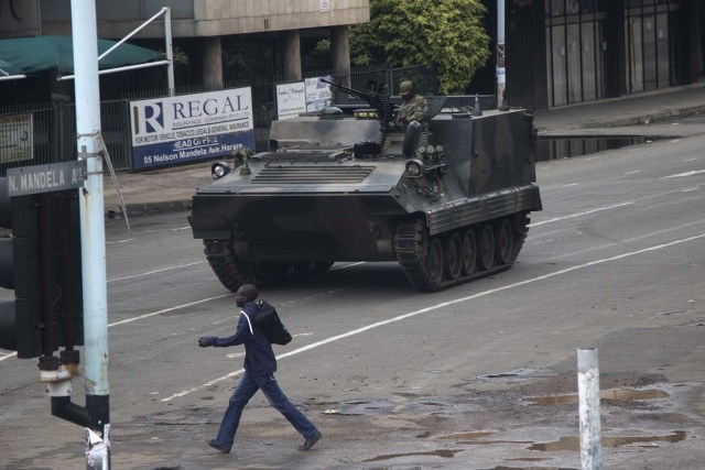 Zimbabwean soldiers stand by an intersection as they regulate civilian traffic in Harare on November 15, 2017. Zimbabwe's military appeared to be in control of the country on November 15 as generals denied staging a coup but used state television to vow to target "criminals" close to President Mugabe. / AFP PHOTO / -