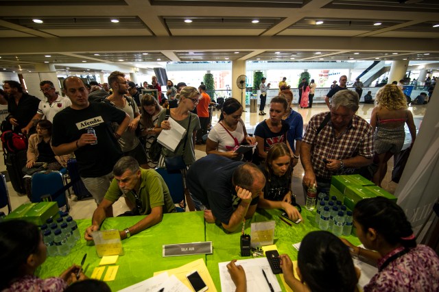 Passengers gather at the Ngurah Rai International airport in Denpasar, Bali on November 28, 2017 to wait for possible flights out following Mount Agung's volcano eruption. Indonesian authorities extended the closure of the international airport on the resort island of Bali for a second day over fears of a volcanic eruption.evacuation and closed the main airport, leaving thousands of tourists stranded on the Indonesian resort island. / AFP PHOTO / JUNI KRISWANTO