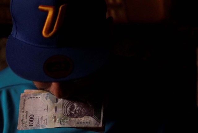 A man counts his money to place bets on horse racing at a small warehouse on the outskirts of Caracas, Venezuela, October 7, 2017. REUTERS/Ricardo Moraes  SEARCH "MORAES GAMBLING" FOR THIS STORY. SEARCH "WIDER IMAGE" FOR ALL STORIES.