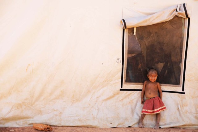 An indigenous Warao child from the Orinoco Delta in eastern Venezuela, stands next to a tent at a shelter in Boa Vista, Roraima state, Brazil November 18, 2017. Picture taken November 18, 2017. REUTERS/Nacho Doce