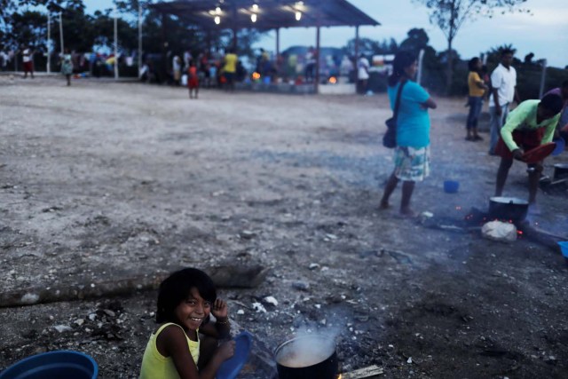 An indigenous Warao child from the Orinoco Delta in eastern Venezuela, smiles next to food at a shelter in Pacaraima, Roraima state, Brazil November 15, 2017. Picture taken November 15, 2017. REUTERS/Nacho Doce