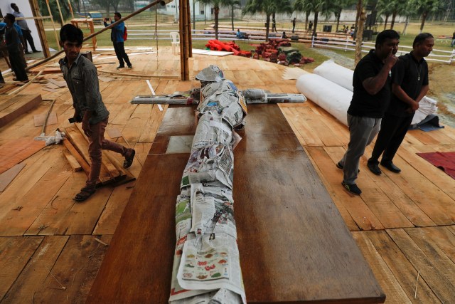 A wooden crucifix is wrapped in newspapers as it's brought to where Pope Francis will hold a mass in a park in Dhaka, Bangladesh November 29, 2017. REUTERS/Damir Sagolj