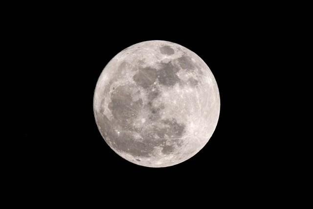 A 'supermoon' is seen in the sky over Hong Kong on December 3, 2017. The lunar phenomenon occurs when a full moon is at its closest point to earth. / AFP PHOTO / Anthony WALLACE