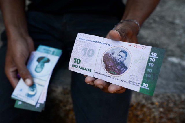 A man shows the new local community currency, the panal, launched in the "23 de Enero" working-class neighbourhood in Caracas on December 15, 2017. A collective in a hilltop shantytown in Caracas created its own currency, the panal, in an attempt to fight chronic shortages of cash in inflation-ridden Venezuela. The currency can be exchanged locally for staples like sugar, rice (produced in the neighborhood itself), and bread. / AFP PHOTO / FEDERICO PARRA