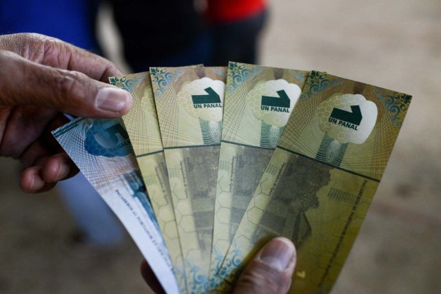 A man shows the new local community currency, the panal, launched in the "23 de Enero" working-class neighbourhood in Caracas on December 15, 2017. A collective in a hilltop shantytown in Caracas created its own currency, the panal, in an attempt to fight chronic shortages of cash in inflation-ridden Venezuela. The currency can be exchanged locally for staples like sugar, rice (produced in the neighborhood itself), and bread. / AFP PHOTO / FEDERICO PARRA