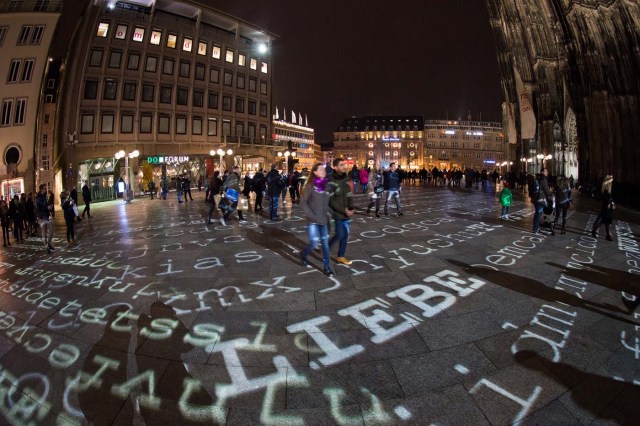 "Love" and other words are being displayed on the ground in front of the Cologne Cathedral on December 30, 2017 in Cologne, western Germany, as part of a light installation by artist Ingo Dietzel. The artist collects wishes from people and integrates them in his work that will be displayed during New Year's Eve celebrations in front of Cologne's most famous landmark, the Cathedral. / AFP PHOTO / dpa / Rainer Jensen / Germany OUT