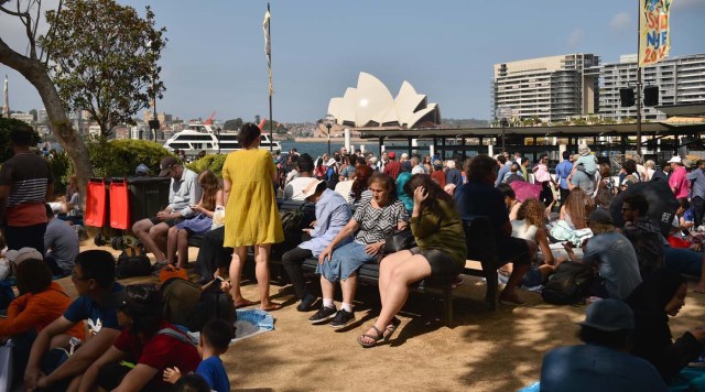 Crowds gather at Circular Quay ahead of the New Year's Eve fireworks display in Sydney on December 31, 2017. Australia's largest city Sydney will welcome 2018 with a rainbow-themed fireworks spectacular marking new same-sex marriage rights, with heavy security for festivities that kick off a wave of celebrations around the world. / AFP PHOTO / PETER PARKS