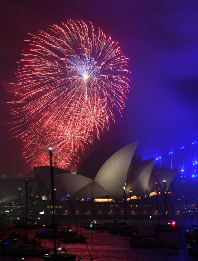 The "family fireworks", displayed three hours before midnight every year ahead of the main show at midnight, fill the sky over the Opera House in Sydney on New Year's Eve on December 31, 2017. / AFP PHOTO / SAEED KHAN