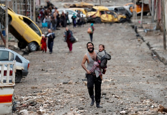 A man cries as he carries his daughter while walking from an Islamic State-controlled part of Mosul towards Iraqi special forces soldiers during a battle in Mosul, Iraq March 4, 2017. Picture taken on March 4, 2017.   REUTERS/Goran Tomasevic/File Photo      SEARCH "POY GLOBAL" FOR THIS STORY. SEARCH "REUTERS POY" FOR ALL BEST OF 2017 PACKAGES.    TPX IMAGES OF THE DAY