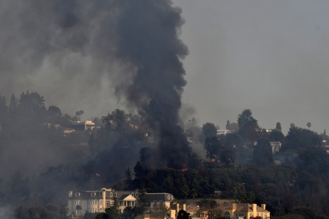 A home burns as a wildfire, dubbed the Skirball Fire, moves through a wealthy neighborhood, on the west side of Los Angeles, California, U.S., December 6, 2017. REUTERS/Gene Blevins