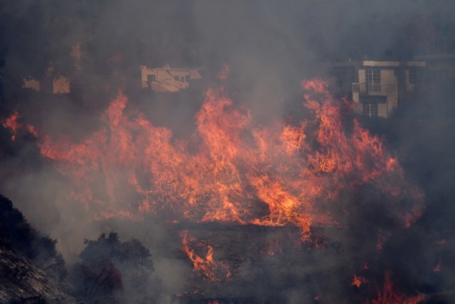 Flames from the Skirball Fire spread on a hillside in a wealthy neighborhood on the west side of Los Angeles, California, U.S., December 6, 2017. REUTERS/Gene Blevins