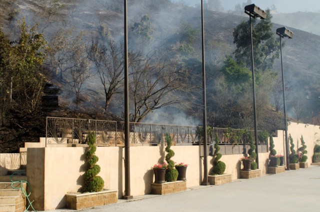 Smoke left from the Skirball fire rises over a private backyard near the Bel Air neighborhood on the west side of Los Angeles, California, U.S., December 6, 2017.      REUTERS/Andrew Cullen