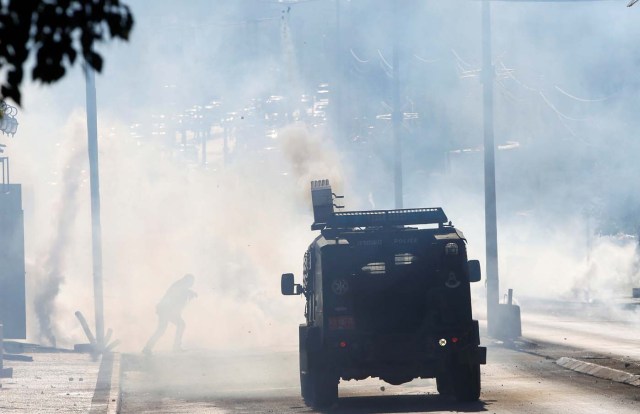 A Palestinian protester runs for cover from tear gas fired by Israeli troops during clashes as Palestinians call for a "day of rage" in response to U.S. President Donald Trump's recognition of Jerusalem as Israel's capital, in the West Bank city of Bethlehem December 8, 2017. REUTERS/Mussa Qawasma