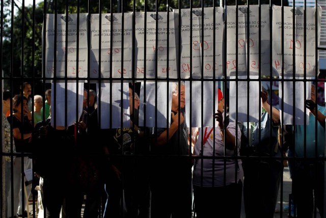 People check a list at a polling station during a nationwide election for new mayors, in Caracas, Venezuela December 10, 2017. REUTERS/Marco Bello