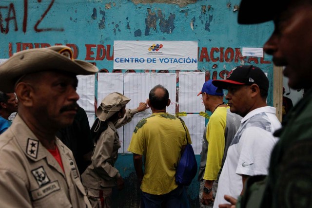 People check a list at a polling station during a nationwide election for new mayors, in Caracas, Venezuela December 10, 2017. REUTERS/Fabiola Ferrero