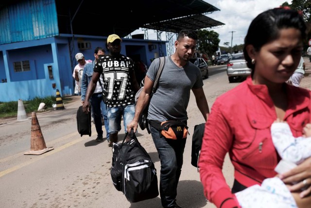 Venezuelans walk to show their passports or identity cards at the Pacaraima border control, Roraima state, Brazil November 16, 2017. The border control is manned by Federal Police during the day. Venezuelans coming in to Brazil line up on the left side and walk across the road to the immigration control where they sit for longer, waiting to have their passport stamped. At night the police leave, no cars can come across, but people can freely walk into Brazil. REUTERS/Nacho Doce SEARCH "VENEZUELAN MIGRANTS" FOR THIS STORY. SEARCH "WIDER IMAGE" FOR ALL STORIES.