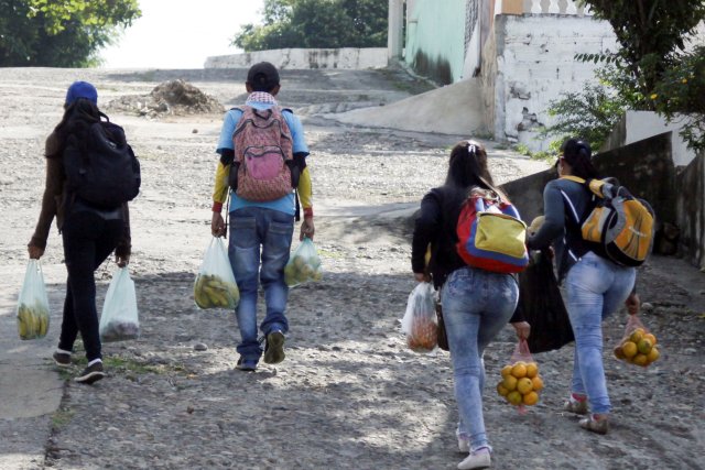 Marlon Carrillo (2nd L) and his relatives carrying bags with fruits bought in Venezuela, walk on the street as they look for clients in Cucuta, Colombia December 15, 2017. Picture taken December 15, 2017. REUTERS/Carlos Eduardo Ramirez