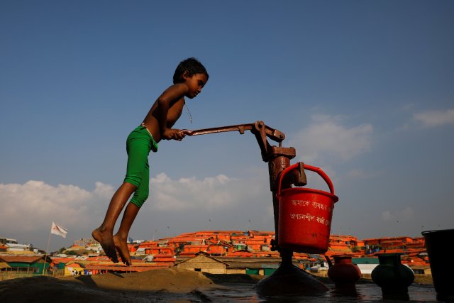 A Rohingya refugee child fills a bucket of water at the Palongkhali refugee camp near Cox's Bazar, Bangladesh December 21, 2017. REUTERS/Marko Djurica