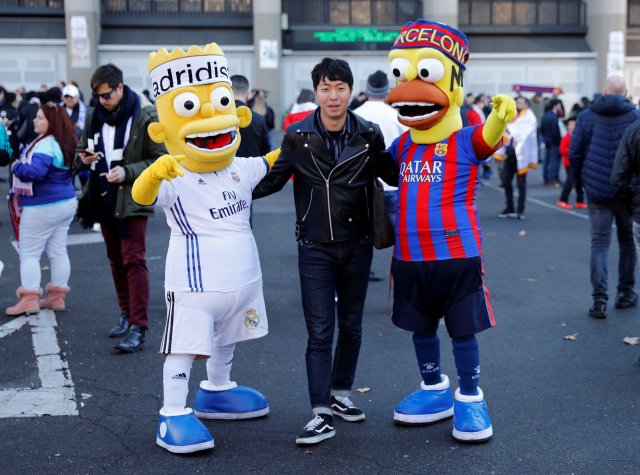 Soccer Football - La Liga Santander - Real Madrid vs FC Barcelona - Santiago Bernabeu, Madrid, Spain - December 23, 2017 Fan with mascots outside the stadium before the match REUTERS/Paul Hanna