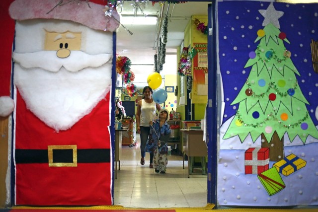 GU301. CIUDAD DE GUATEMALA (GUATEMALA), 20/12/2017.- Un niño paciente del Hospital San Juan de Dios juega con unos globlos que Santa Claus le regaló hoy, miércoles 20 de diciembre de 2017, en la ciudad de Guatemala (Guatemala). Santa Claus visitó el segundo hospital público más grande de Guatemala para entregar regalos a los niños, actividad que se ha realizado por 34 años consecutivos. EFE/Esteban Biba