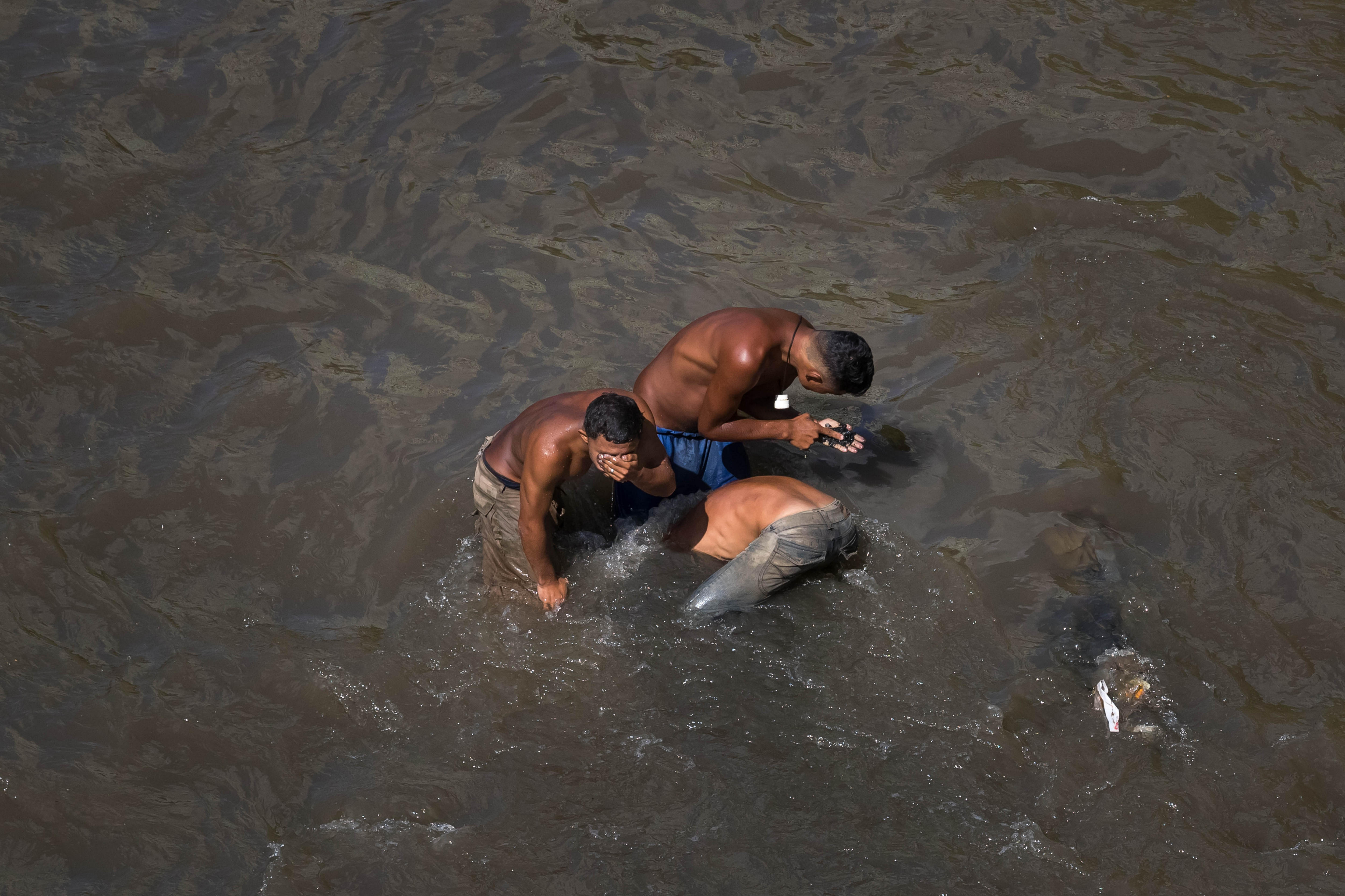 DRAMÁTICO: Los “mineros” venezolanos no sacan bitcoins… sino basura de El Guaire (FOTOS)