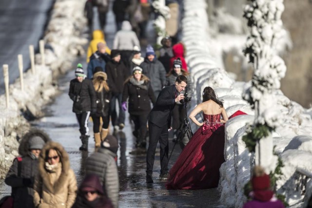 Jonathan Czitkovics and his wife Yvonne Chen take wedding photos in Niagara Falls, Ontario on January 3, 2018. The couple were married this summer in Thailand where they live but wanted to do some wedding photos in Canada, since Jonathan is from Montreal. The cold snap which has gripped much of Canada and the United States has nearly frozen over the American side of the falls. / AFP PHOTO / Geoff Robins