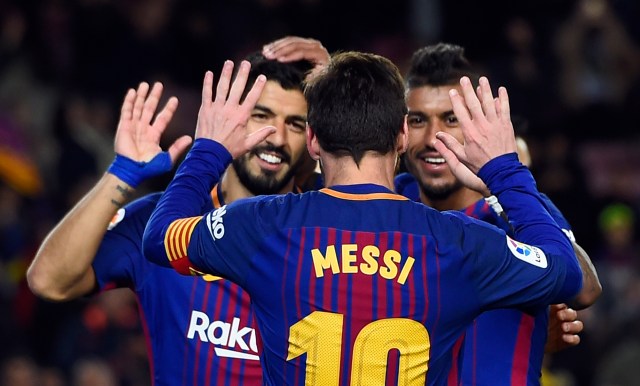 Barcelona's Brazilian midfielder Paulinho (R) celebrates a goal with Barcelona's Argentinian forward Lionel Messi and Barcelona's Uruguayan forward Luis Suarez (L) during the Spanish league football match FC Barcelona vs Levante UD at the Camp Nou stadium in Barcelona on January 7, 2018. / AFP PHOTO / Josep LAGO