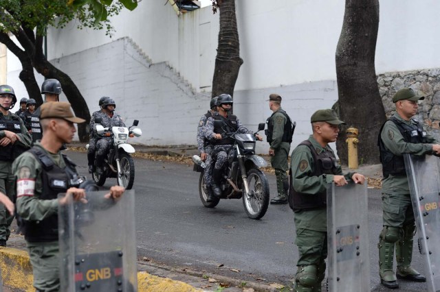 Security forces block access to the morgue in Caracas where the bodies of rogue pilot Oscar Perez and six other "terrorists" killed during a bloody police assault to arrest them, are being kept on January 17, 2018. Venezuela's government announced Tuesday that Perez was among seven "terrorists" killed when police swooped on them outside Caracas on Monday, setting off a fierce gunbattle in which two police officers were also killed. Perez had been wanted since he used a stolen helicopter to bomb Venezuela's Supreme Court at the height of anti-government protests last June. / AFP PHOTO / Federico PARRA