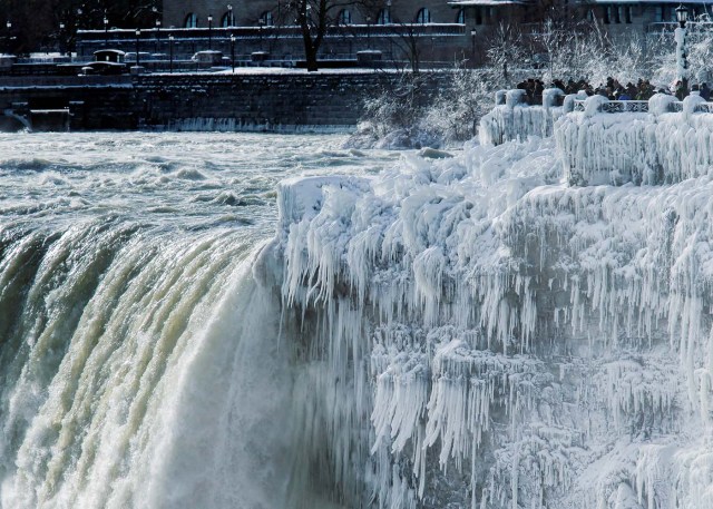 Visitors take pictures near the brink of the ice covered Horseshoe Falls in Niagara Falls, Ontario, Canada, January 3, 2018. REUTERS/Aaron Lynett