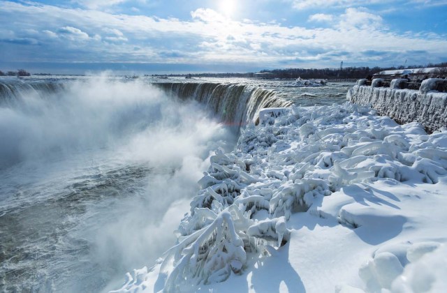 Visitors take pictures near the brink of the ice covered Horseshoe Falls in Niagara Falls, Ontario, Canada, January 3, 2018. REUTERS/Aaron Lynett