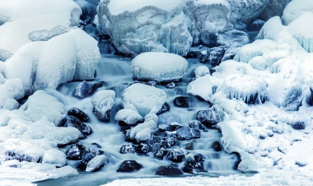 Water flows over ice forming at the base of the American Falls, viewed from the Canadian side in Niagara Falls, Ontario, Canada, January 3, 2018. REUTERS/Aaron Lynett