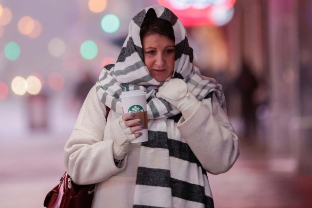 A woman walks in Times Square during a winter storm in Manhattan, New York, U.S. January 4, 2018. REUTERS/Jeenah Moon