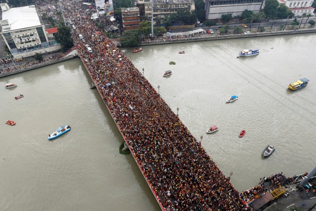 Devotees flock as a carriage bearing an image of the Black Nazarene makes its way through the Jones bridge in Manila, Philippines, January 9, 2018. REUTERS/Erik  De Castro