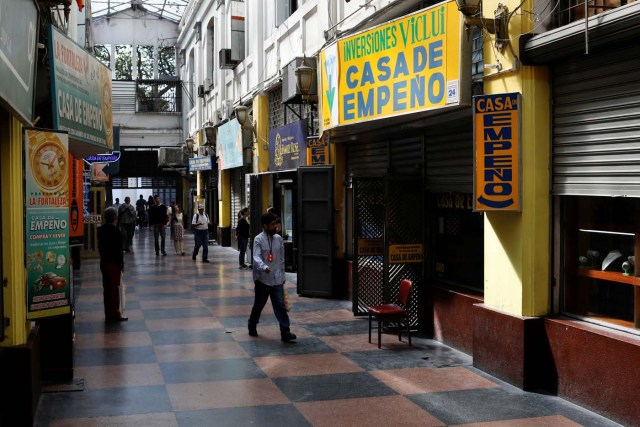 People walk in front of pawn shops in downtown Caracas, Venezuela January 9, 2018. REUTERS/Marco Bello