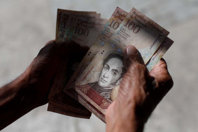 A man counts Venezuelan bolivar notes in downtown Caracas, Venezuela January 9, 2018. REUTERS/Marco Bello