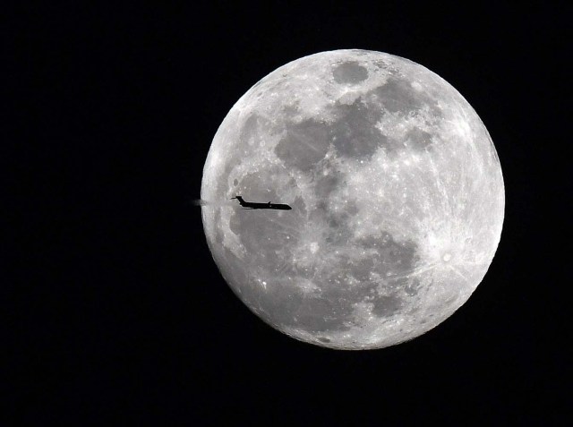 Jan 30, 2018; Senoia, GA, USA; Delta flight 1789 a MD-90 aircraft from Atlanta to Jacksonville transits across the super moon over the evening sky in Georgia. A rare celestial phenomenon when a super moon, blue moon and total lunar eclipse will take place at the same time in the early morning hours of Jan 31st. Mandatory Credit: John David Mercer-USA TODAY Sports TPX IMAGES OF THE DAY