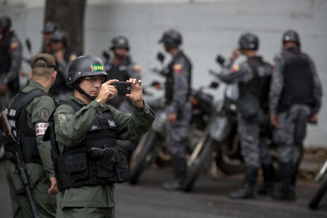 CAR04. CARACAS (VENEZUELA), 17/01/2018.- Miembros de la Guardia Nacional Bolivariana y la Policía Nacional Bolivariana custodian las inmediaciones de la morgue en donde está cuerpo del exagente Pérez hoy, miércoles 17 de enero de 2018, en Caracas (Venezuela). Decenas de agentes de la Policía Nacional Bolivariana custodian desde la mañana de hoy los alrededores de la principal morgue de Caracas, después de que familiares de Óscar Pérez, el exagente alzado contra el Gobierno chavista quien falleció el lunes, exigieran identificar su cuerpo. EFE/MIGUEL GUTIÉRREZ