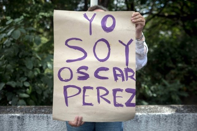 Una mujer sostiene un cartel frente a la morgue en Caracas en donde está el cuerpo de Óscar Pérez. Credit Miguel Gutierrez/European Pressphoto Agency