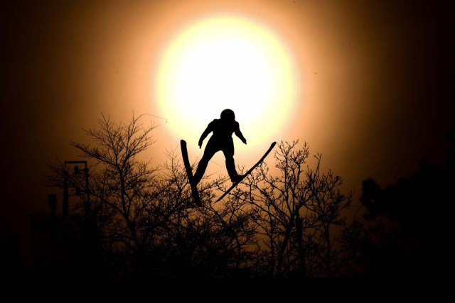 Italy's Alessandro Pittin flies through the sun disk during the nordic combined men's individual Gundersen LH/10km official training 3 at the Alpensia ski jump centre during the Pyeongchang 2018 Winter Olympic Games on February 19, 2018 in Pyeongchang. / AFP PHOTO / Kirill KUDRYAVTSEV