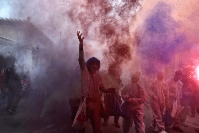 Revellers take part in the "flour war" during the celebration of "Ash Monday", a traditional festivity marking the end of the carnival season and the start of the 40-day Lent period until the Orthodox Easter, in the port town of Galaxidi, on February 19, 2018. / AFP PHOTO / LOUISA GOULIAMAKI