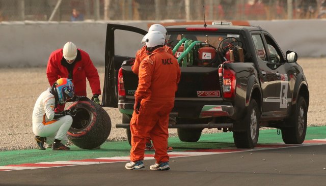 F1 Formula One - Formula One Test Session - Circuit de Barcelona Catalunya, Montmelo, Spain - February 26, 2018 Fernando Alonso of McLaren inspects the tyre that fell off his car during testing REUTERS/Albert Gea