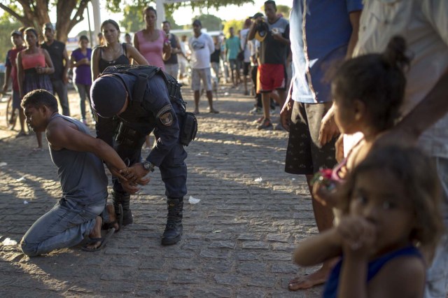 A man is detained inside the improvised Venezuelan refugee camp at Simon Bolivar square, accused of trying to molest a child, in the city of Boa Vista, Roraima, Brazil, on February 25, 2018. According to local authorities, around one thousand refugees are crossing the Brazilian border each day from Venezuela. With the constant influx of Venezuelan immigrants, most are living in shelters and the streets of Boa Vista and Pacaraima cities, looking for work, medical care and food. Most are legalizing their status to stay and live in Brazil. / AFP PHOTO / Mauro PIMENTEL