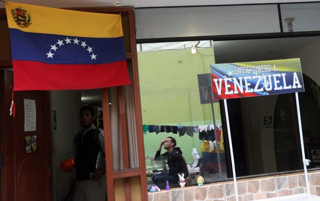 Venezuelan migrants stand next to a sign reading: ' Send money to Venezuela' at a shelter for Venezuelans in San Juan de Lurigancho, on the outskirts of Lima, Peru March 9, 2018. REUTERS/Mariana Bazo