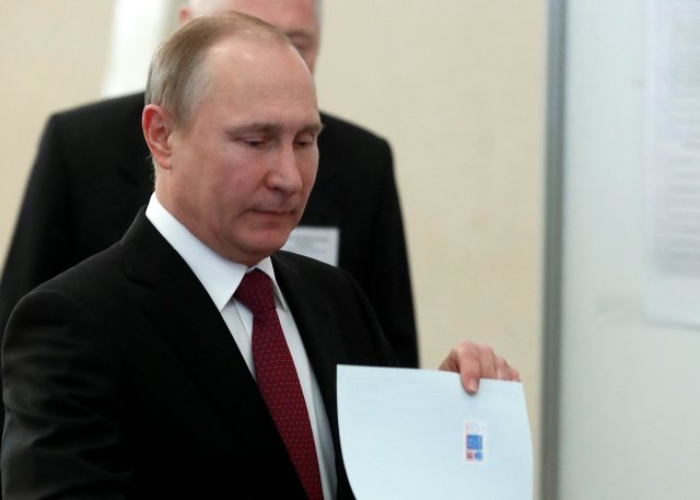 El presidente ruso y candidato presidencial Vladimir Putin emitirá su voto en una mesa de votación durante las elecciones presidenciales en Moscú, Rusia el 18 de marzo de 2018. Sergei Chirkov / POOL vía Reuters
