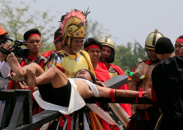 Ruben Enaje, 58, who is portraying Jesus Christ for the 32nd time, grimaces in pain as he is nailed on a wooden cross during a Good Friday crucifixion re-enactment in Cutud village, Pampanga province, north of Manila, Philippines March 30, 2018. REUTERS/Romeo Ranoco