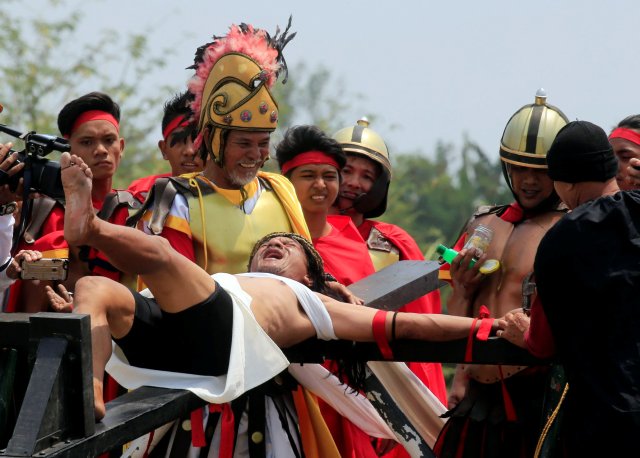 Ruben Enaje, 58, who is portraying Jesus Christ for the 32nd time, grimaces in pain as he is nailed on a wooden cross during a Good Friday crucifixion re-enactment in Cutud village, Pampanga province, north of Manila, Philippines March 30, 2018. REUTERS/Romeo Ranoco