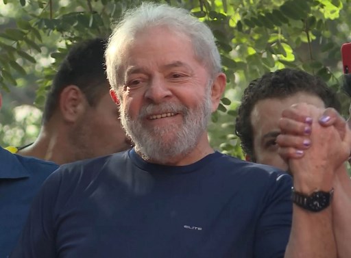 This screen grab shows Brazilian ex-president (2003-2011) Luiz Inacio Lula da Silva waving to supporters at the metalworkers' union building in Sao Bernardo do Campo, in metropolitan Sao Paulo, Brazil, on April 7, 2018. Lula da Silva attended a mass for his late wife Marisa Leticia Saturday at the metalworkers' union building, where he remained entrenched for two days while his lawyers negotiated his surrendering to police. Lula is facing 12 years behind bars for taking bribes and money laundering.  / AFP PHOTO / Carlos Reyes