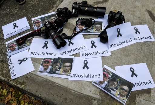 Imagen detallada tomada cuando periodistas colombianos se reúnen frente a la embajada ecuatoriana en Bogotá para protestar contra el asesinato del periodista ecuatoriano Javier Ortega, el fotógrafo Paul Rivas y su conductor Efraín Segarra, el 16 de abril de 2018. Los tres miembros de un equipo de periodistas ecuatorianos que fueron secuestrados y asesinados en cautiverio luego de ser secuestrados por un grupo rebelde colombiano que seguían una historia sobre violencia que terminó costando sus vidas.